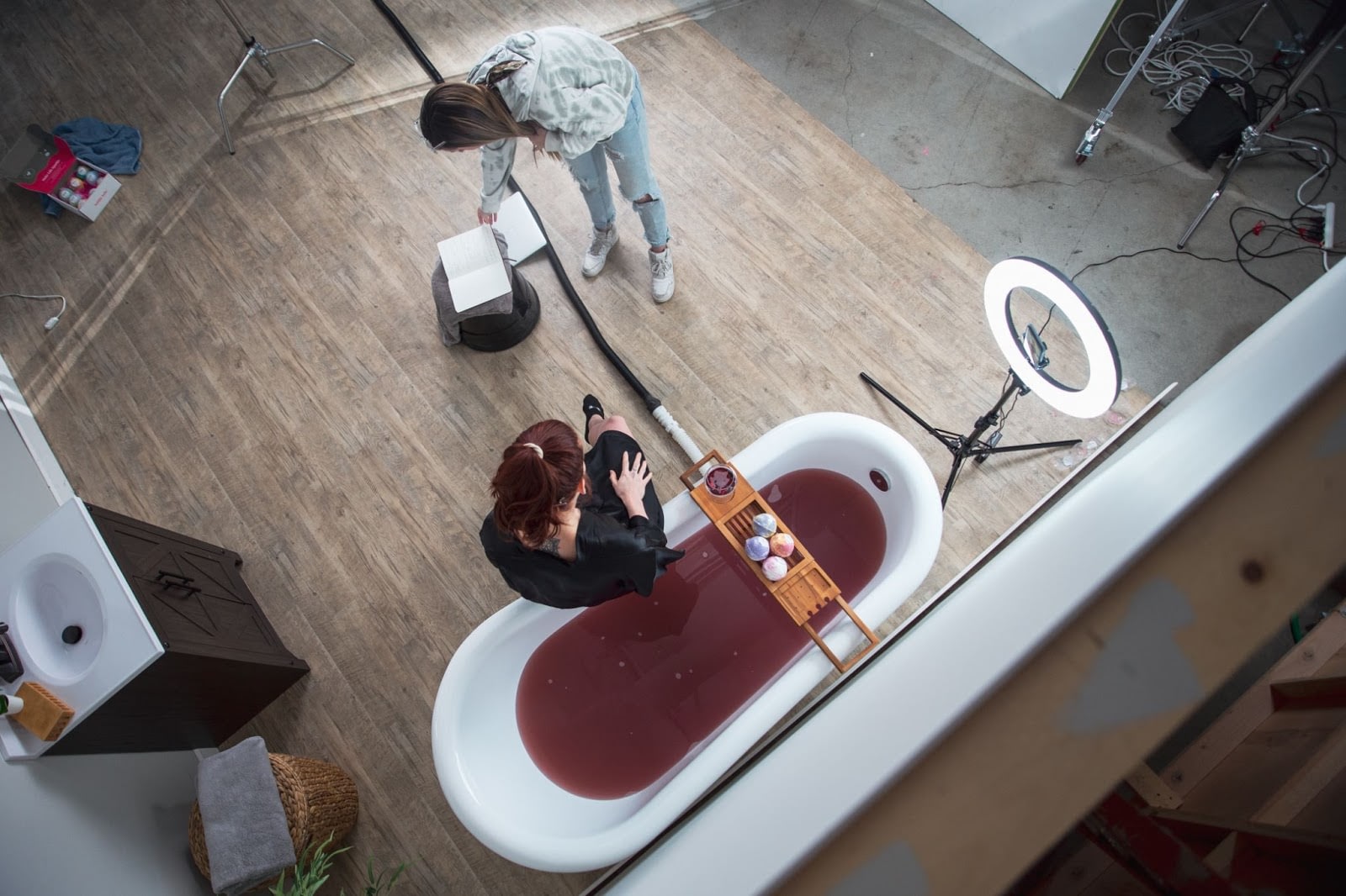 camera crew setting up around a bath filled with red fluid